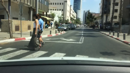 a driving scene with pedestrians on a crosswalk